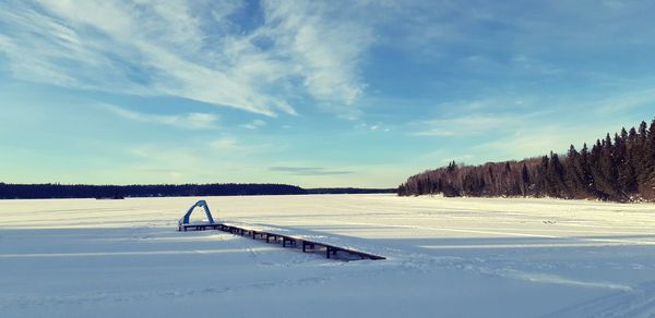 Scenic view of snow covered field against sky