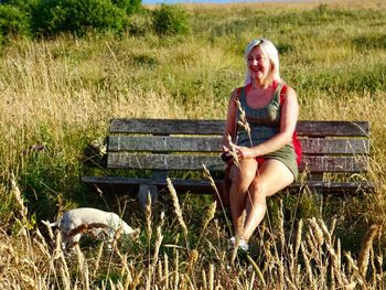 Portrait of smiling young woman sitting on field