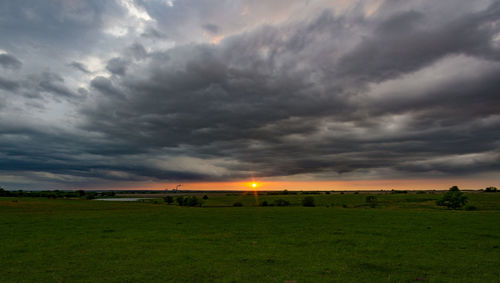 Scenic view of field against dramatic sky