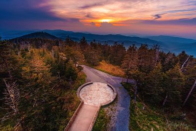 High angle view of road amidst trees against sky during sunset