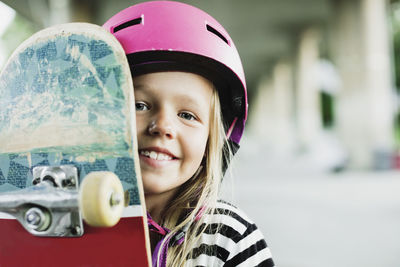 Portrait of happy girl with skateboard at park