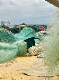 Fishing net on beach against sky