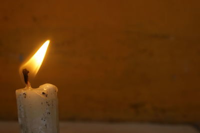 Close-up of lit candle in the dark