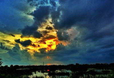 Scenic view of dramatic sky over silhouette landscape