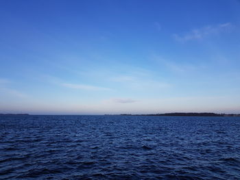 Scenic view of sea against blue sky