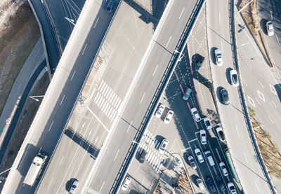 Cars drive along traffic intersection in the city, aerial view.