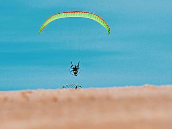 Person paragliding against sky