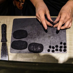 Cropped hand of man preparing food on table