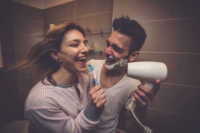 Young couple standing against wall