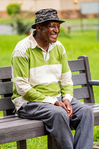 Full length of man sitting on bench in park