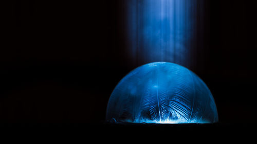 Close-up of illuminated lighting equipment against black background