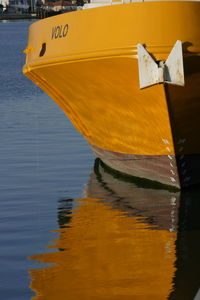 Close-up of yellow boat moored at lake during sunset