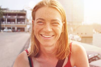 Close-up portrait of cheerful mature woman in city