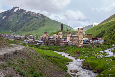 Scenic view of houses and mountains against sky