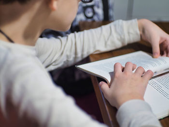 Midsection of teen reading book