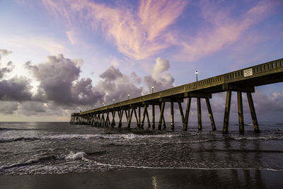 Pier over sea against sky during sunset