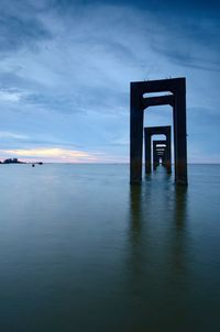 Pier over sea against sky during sunset