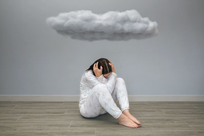Portrait of young woman standing against wall