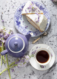 Still life with black tea and cheese cake, spring bouquet,delicate lilac flowers
