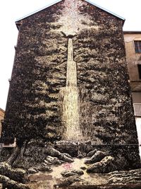 Low angle view of text on building against sky