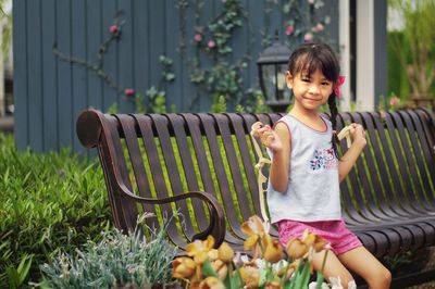 Portrait of smiling girl standing by plants