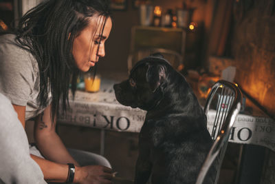 Midsection of woman with dog sitting on table