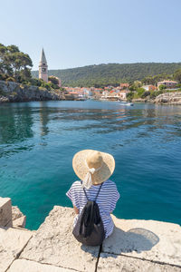 Rear view of woman looking at sea against clear sky