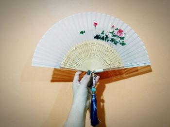 Cropped image of woman hand holding folding fan