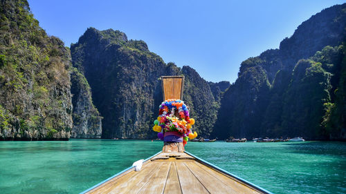 Man on boat by mountain against sky