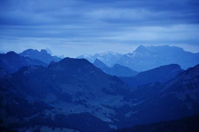 Scenic view of mountains against sky at dusk