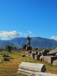 View of cross on mountain against blue sky