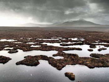 Scenic view of scottish flow country peat bog against sky during winter
