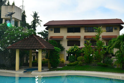 Houses by swimming pool in city against sky