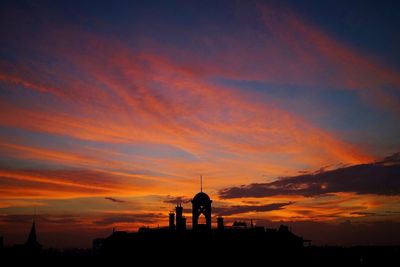 Silhouette city against sky during sunset