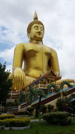 Low angle view of statue against temple against sky