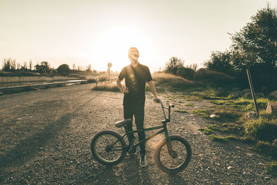 Man riding bicycle on road against sky