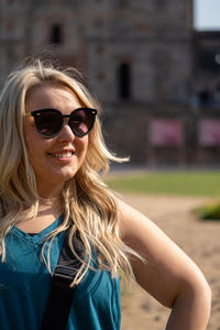 Close-up of smiling woman wearing sunglasses standing outdoors