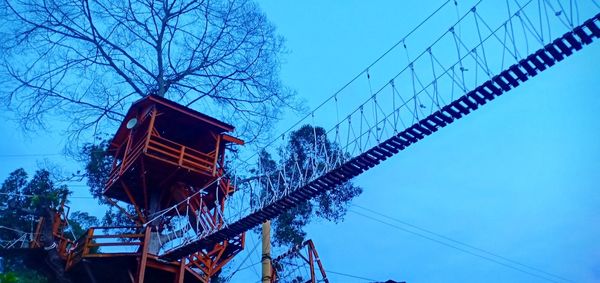 Low angle view of crane against clear blue sky