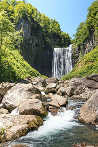 Scenic view of waterfall against rocky mountains