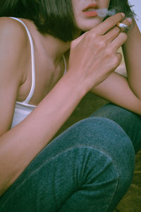 Close-up of woman sitting by potted plant