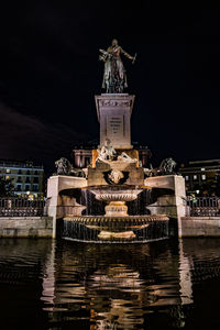 Statue of illuminated fountain at night