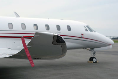 Close-up of airplane on runway against sky