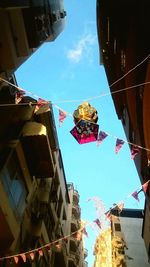 Low angle view of flags hanging against sky