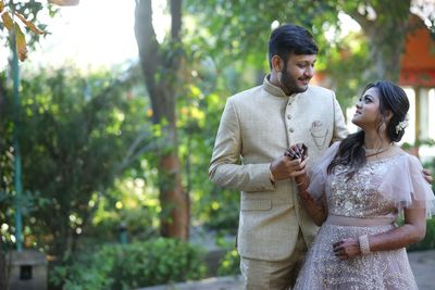 Young couple standing against trees