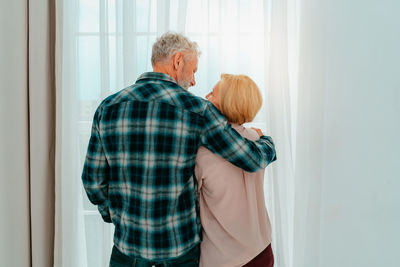 Rear view of couple standing at home