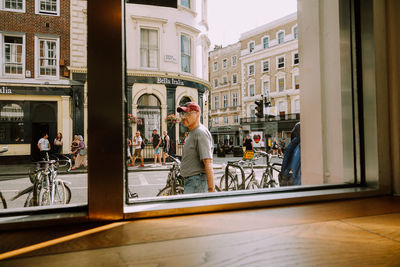 Full length of woman standing on table by window