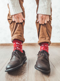 Young man shows bright red socks with reindeers on them. casual outfit for new year and christmas.