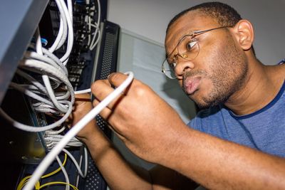 Side view of man working with wires