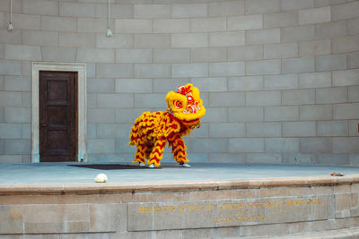 Rear view of woman standing against wall