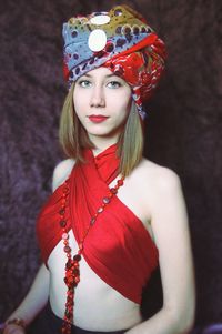 Portrait of young beautiful woman in bandana standing against wall